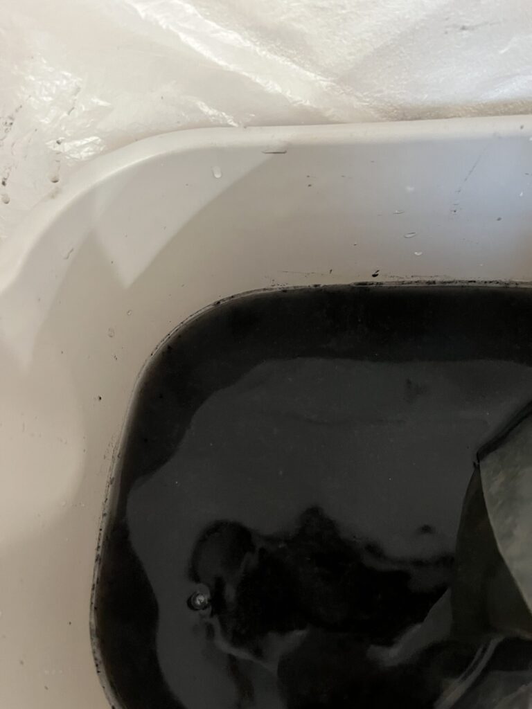 キッチン真横のエアコンをクリーニングした汚水は6年分のカビとキッチンからの油を吸ってより漆黒に