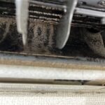 カビが煤のごとくこびり付いた、エアコンのシロッコファンとルーバー