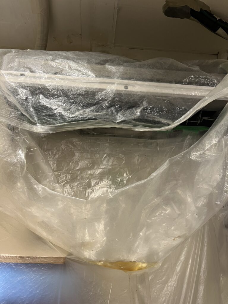 飲食店のキッチン内エアコンに洗剤を塗布し、油汚れが溶け出している