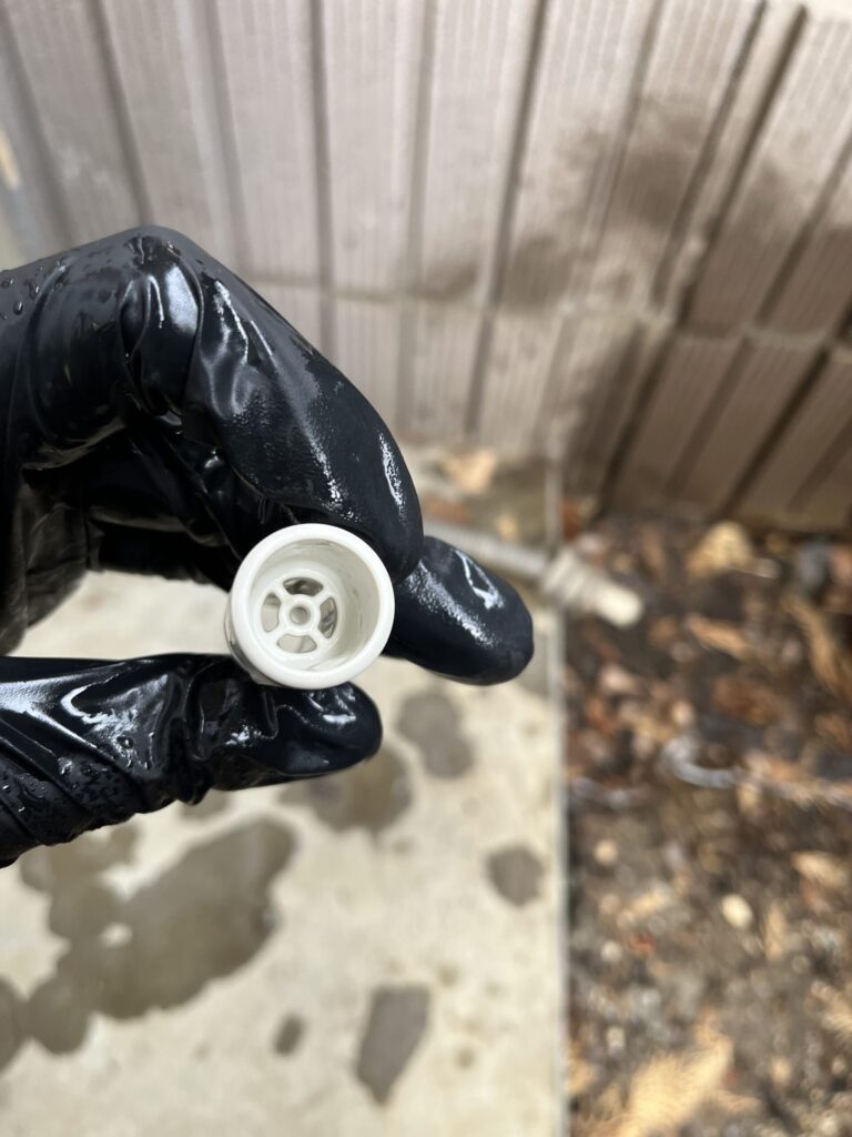 穴が見えないほどに詰まっていたエアコンのドレンホース用防虫キャップが、高圧洗浄機できれいに汚れを落とし、穴がはっきりと見えるようになった
